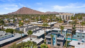 A modern hotel complex with multiple buildings, a pool area, and a mountain in the background. - Walkable Old Town Scottsdale, Heated Poolside Mid Century Condo. (Scottsdale)
