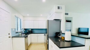 A modern kitchen with white cabinets, a black countertop, and a blue backsplash. - Pool front Condo, steps from memorable Old Town. (Scottsdale)