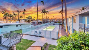 A rooftop pool area with a sunset view, surrounded by palm trees and modern buildings. - Unique poolside studio -  less than a mile to Old Town (Scottsdale)