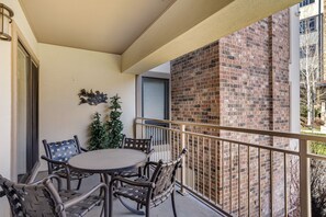 Enjoy a quiet moment on the balcony with a round table and four chairs, surrounded by a potted plant.
