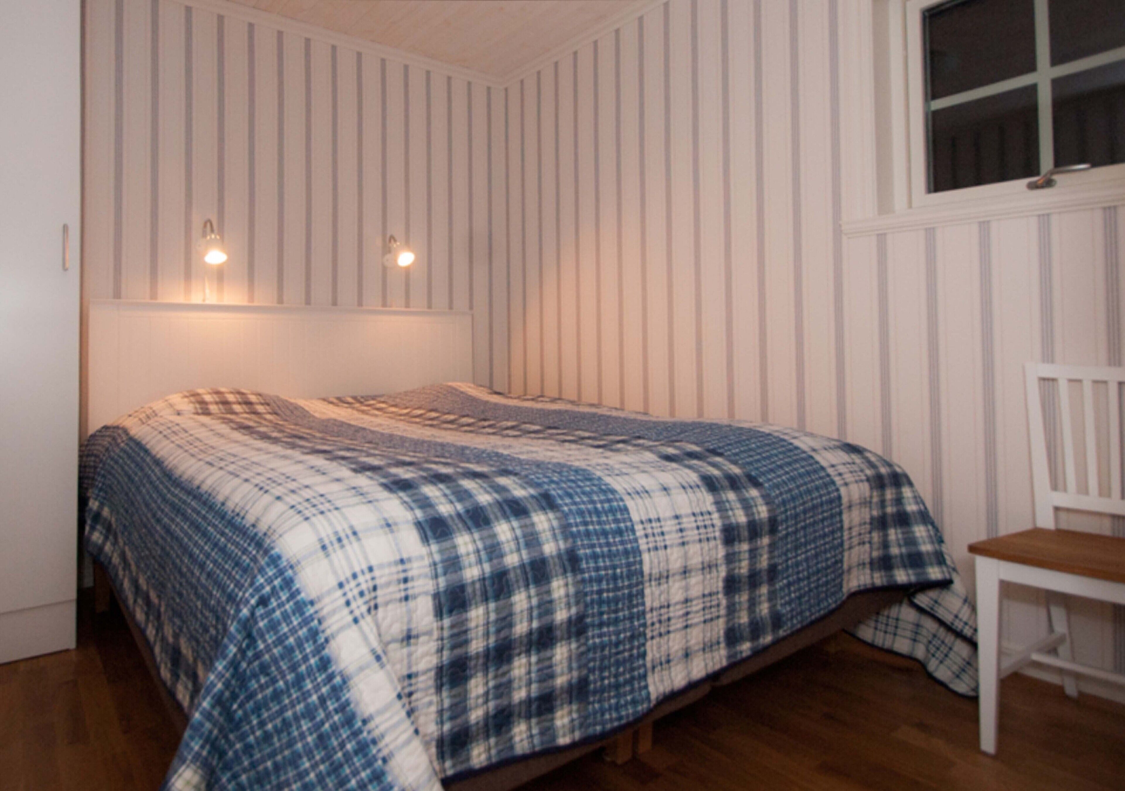 Une chambre à coucher avec un lit, une chaise et une fenêtre.