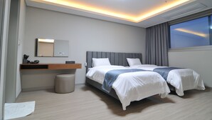 A modern hotel room with a large bed, a bedside table, a mirror, and a window with curtains. - Dasan Beache Golf & Resort (Gangjin)
