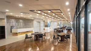 A modern restaurant with wooden flooring, long tables, and a marble backsplash. - Dasan Beache Golf & Resort (Gangjin)