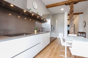 Enjoy cooking in this well-equipped kitchen with a large island, sink, and stainless steel oven.