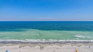 Una playa con agua turquesa transparente y una orilla arenosa.