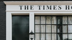 Eine schwarze Tür mit dem Schild "The Times Hotel" darüber.