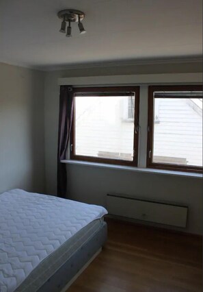 A bedroom with a bed, a window, and a ceiling fan. -  Keybutler City Apartment Henrik Wergelands (Kristiansand)