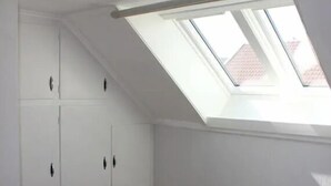A room with a skylight, wooden flooring, and white walls. -  Keybutler City Apartment Henrik Wergelands (Kristiansand)