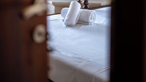 Una habitación con una cama, un reloj en la pared y una chimenea al fondo.