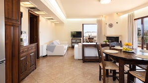 Una sala de estar moderna con comedor, televisor y chimenea.