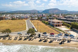 Une ville côtière avec une plage, des voitures garées et des bâtiments.