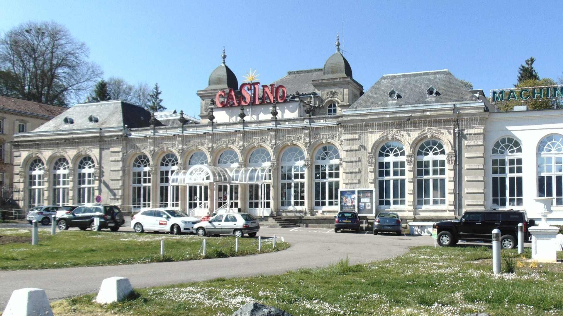 Un edificio histórico con un llamativo letrero de casino, amplias ventanas arqueadas y un estilo arquitectónico clásico.