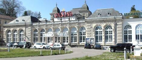 Un edificio histórico con un llamativo letrero de casino, amplias ventanas arqueadas y un estilo arquitectónico clásico.