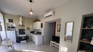 A compact living space with a kitchenette, a dining area, and a seating area. - Côté Jardin" self-catering cottage, Contrexéville spa resort (Contrexéville)