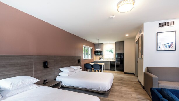 A hotel room with two beds, a kitchenette, a dining area, and a sofa. - Rolo Beach Hotel (Fort Lauderdale)