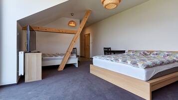 Een slaapkamer met een stapelbed, een bureau en een hanglamp.