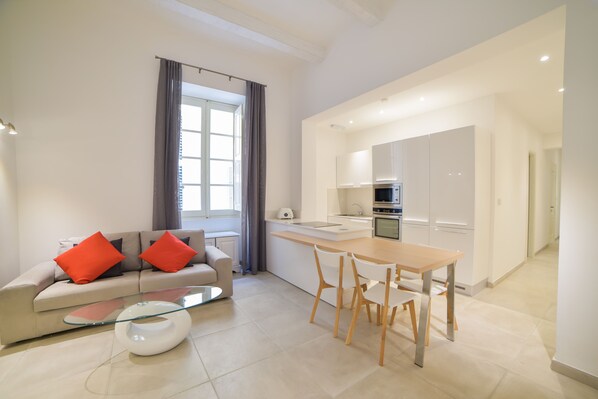 A modern apartment with a living area, kitchenette, and dining space.