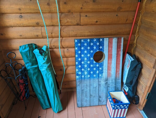 LâintĂ©rieur dâun chalet en bois, avec une porte dĂ©corĂ©e aux couleurs dâun drapeau, un porte-manteau et une boĂźte de rangement.
