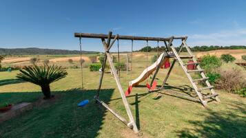Children can play on the swing set and slide in this open grassy area.