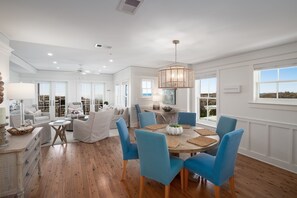 Un salón amplio con comedor, ventanas grandes y vistas al exterior.