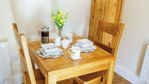 Ein Holztisch mit weißem Geschirr und einer Kaffeekanne.