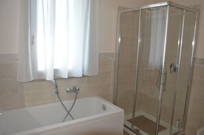 Tina con regadera, secadora de cabello, bidet, toallas 