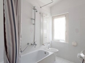 Een bad/douchecombinatie,  milieuvriendelijk toiletgerief