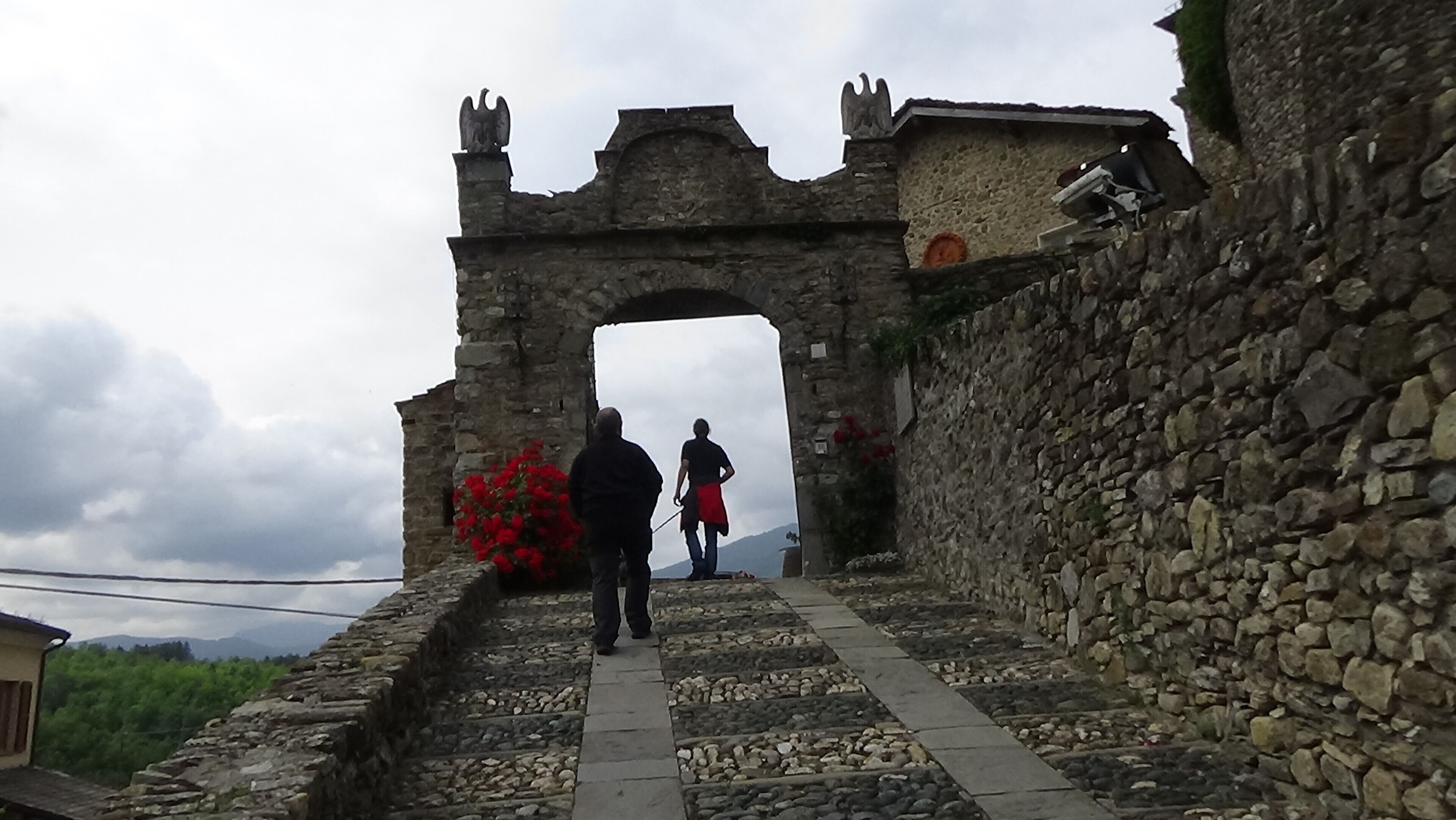 Un sendero de piedra que lleva a un arco con estatuas en la parte superior.