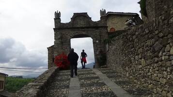 Un sendero de piedra que lleva a un arco con estatuas en la parte superior.