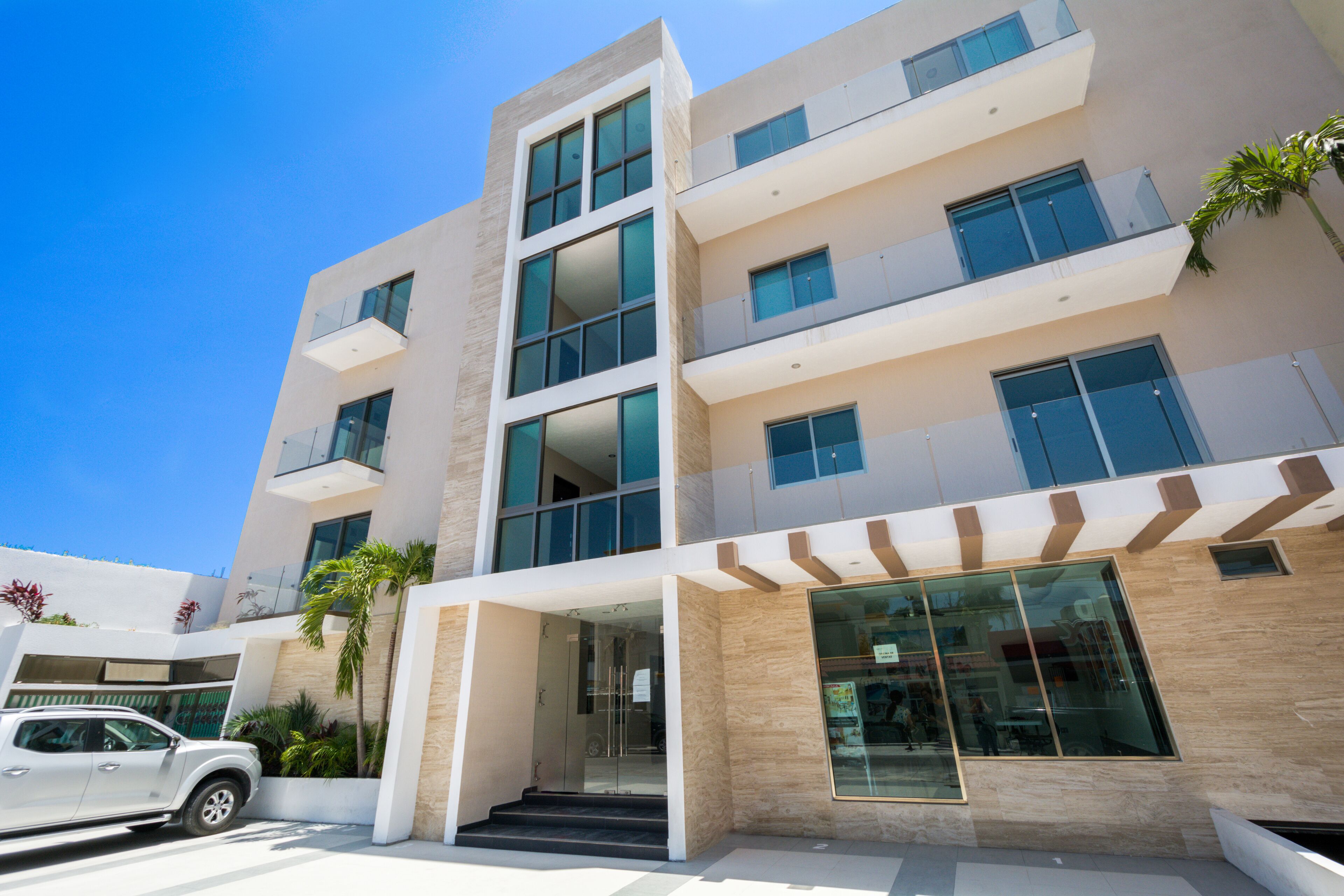 A multi-story hotel with a modern design, featuring large windows and balconies.