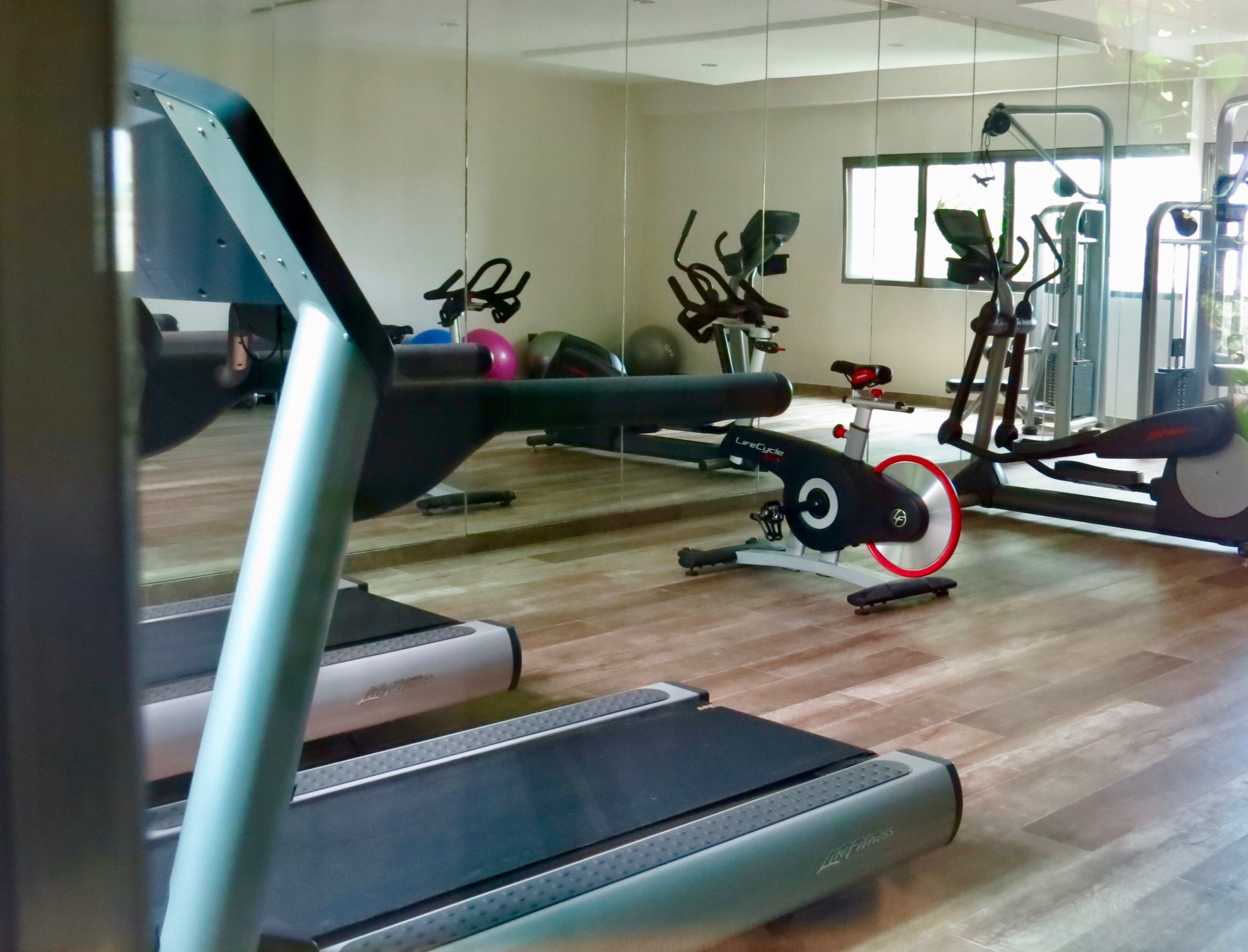 A gym with a treadmill, elliptical, and stationary bikes.