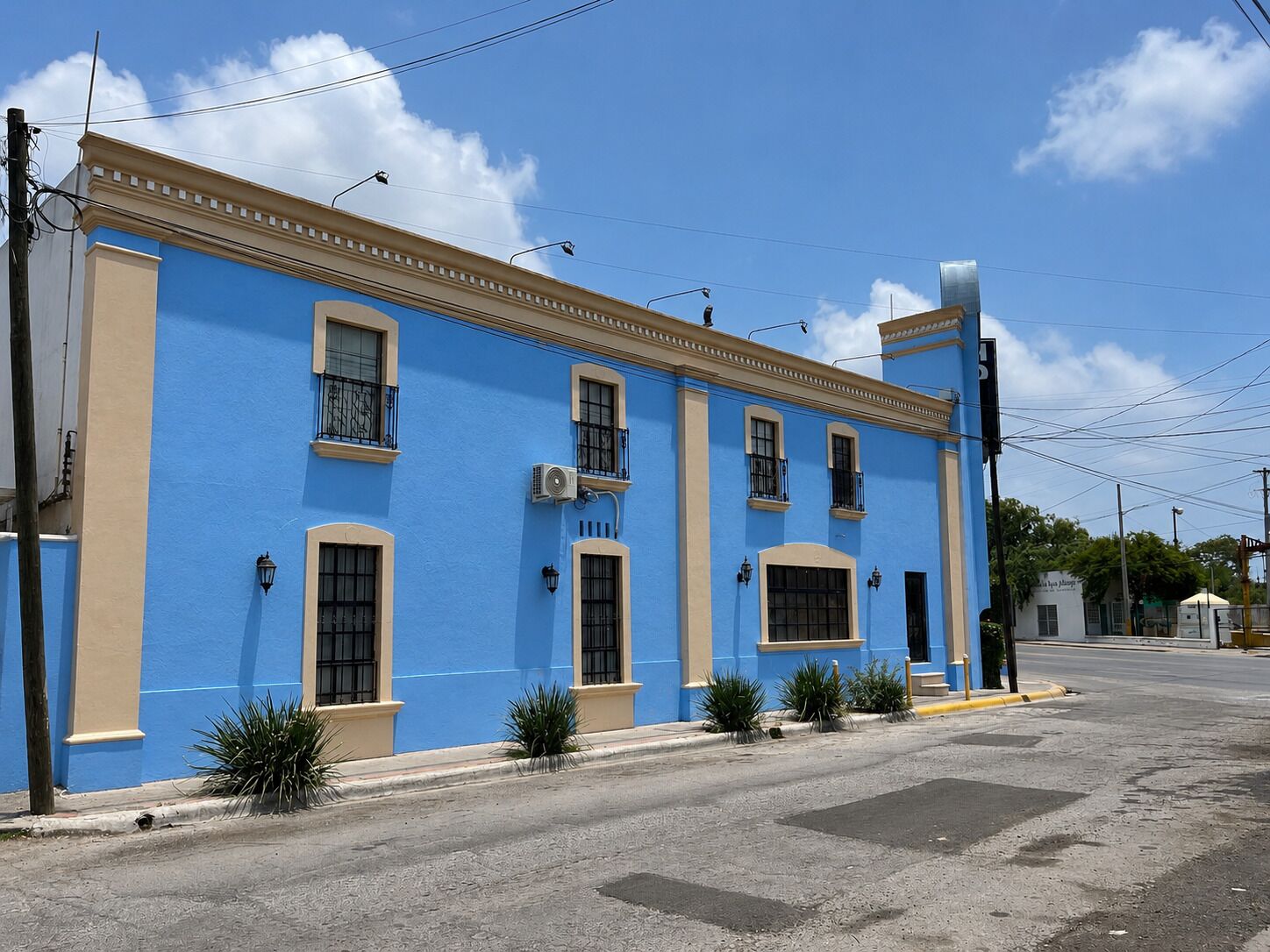 A blue building with multiple windows and a flat roof.