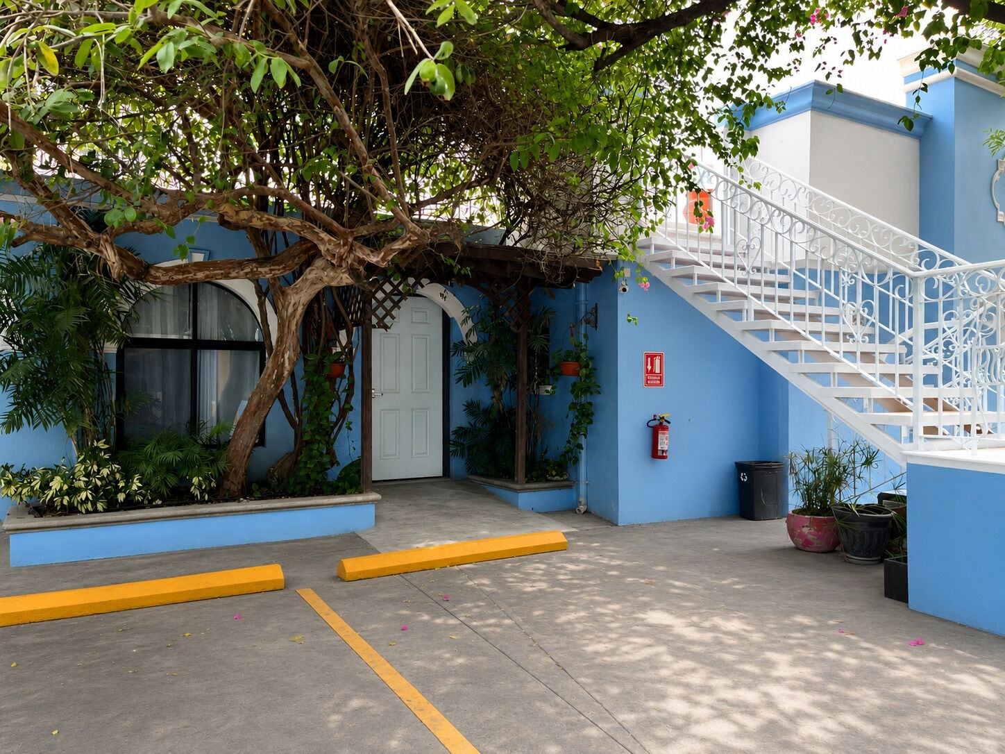 A building with a blue exterior, a white door, and a white staircase.