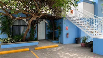 A building with a blue exterior, a white door, and a white staircase.