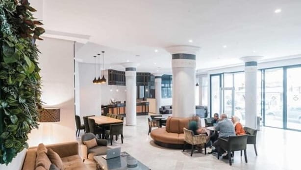 A modern lobby with a seating area, a dining space, and a kitchen in the background. - Casablanca Hotel (Casablanca)