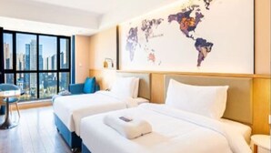 A hotel room with two beds, a large window with a city view, and a world map on the wall. - Kyriad Marvelous Hotel (Xi'an)