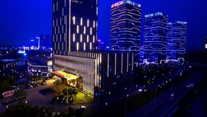 A modern hotel with a prominent 'Wanda Realm' sign, featuring a sleek, contemporary design with vertical lines and a flat roof. - Wanda Realm Guangzhou Zengcheng (Guangzhou)