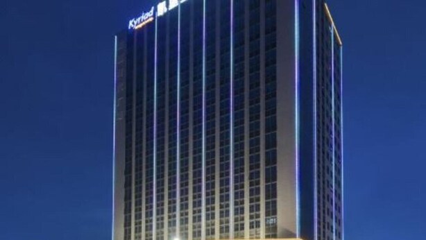 Ett högt hotell med en modern design, som kännetecknas av en stor, väl synlig skylt med texten "KYLOD" på toppen.