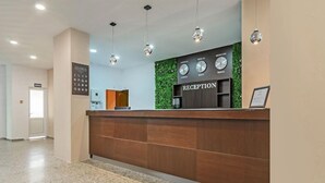 A reception desk with a clock displaying times for London, Berlin, Moscow, and Vienna. - Gloria Saints Constantine And Helena (Varna)