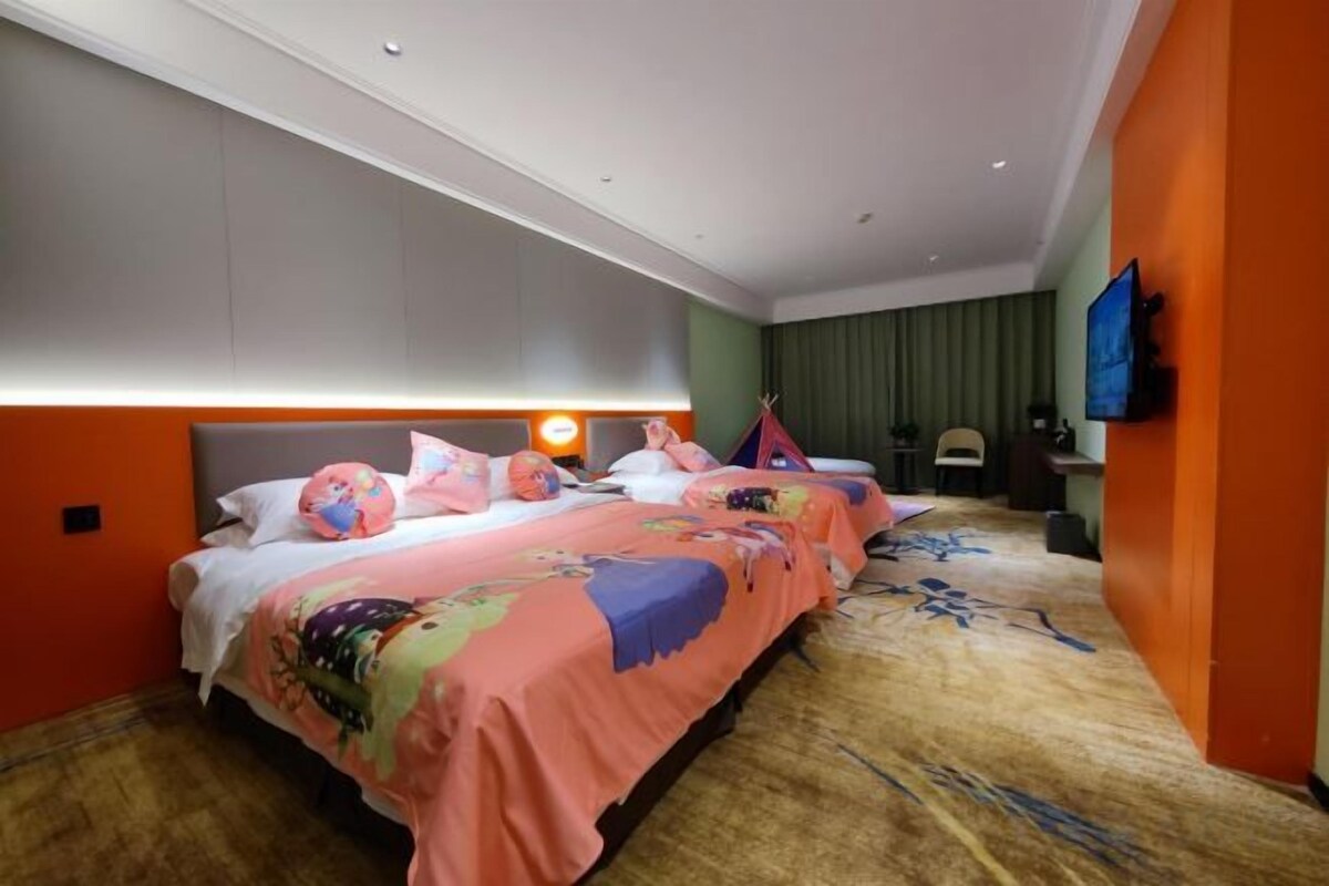 Habitación de hotel con dos camas, un ventanal grande, un televisor de pantalla plana y un escritorio.