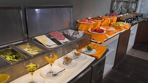 Un bufé con diversas opciones de comida y bebidas.