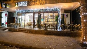 A hotel entrance with outdoor seating and a Christmas tree.