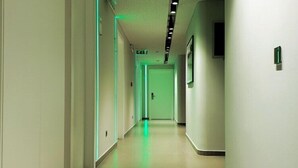 A long, narrow hallway with a tiled floor and white walls.