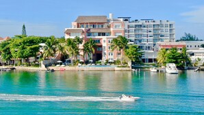 Un hôtel situé au bord de l’eau, composé de plusieurs bâtiments, doté d’un port de plaisance et bordé de palmiers.