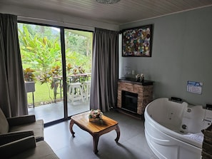 Suite con Jacuzzi y vista al volcan | บริเวณนั่งเล่น | ทีวีจอแบน 40 นิ้ว พร้อมช่องดาวเทียม, ทีวี, เตาผิง