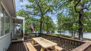 A wooden deck with a picnic table, a grill, and an American flag. - Wake Zone @ Lighthouse Lodge – Lake Views & Easy Water Access! (Kimberling City)