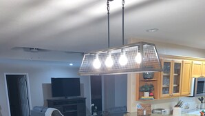 Een moderne woonkamer met een eettafel, bank en televisie.
