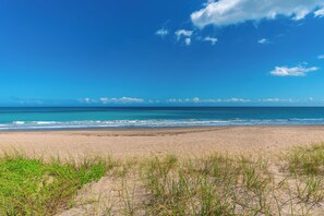 A beach with a clear sky, waves, and distant clouds. - Del Mar al Cielo:  Luxury Beachfront Estate ON the Beach! w/elevator+pool! (Stuart)