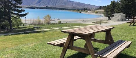 Una mesa de picnic con vista a un lago y montañas.
