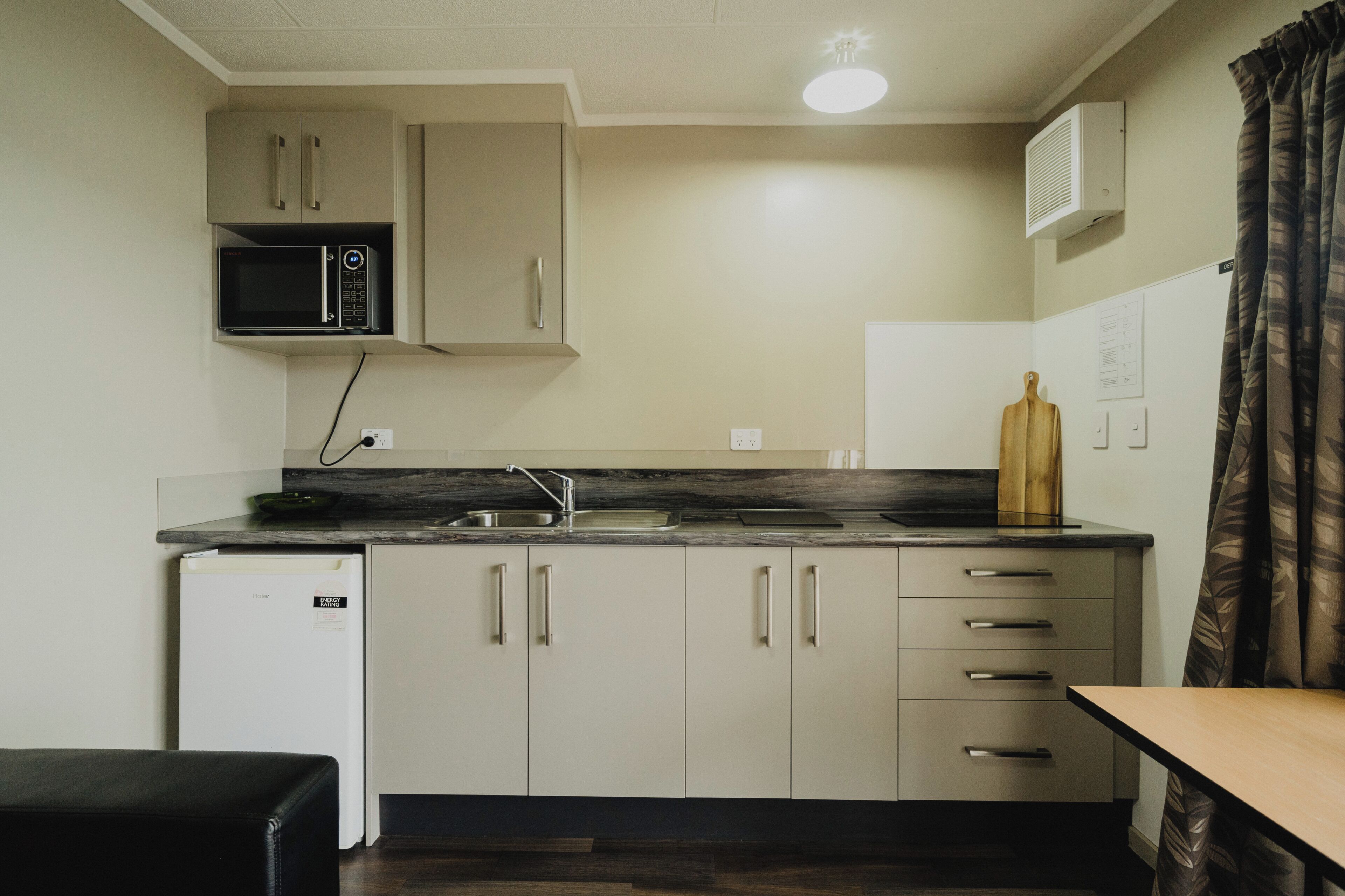 Cocina compacta con microondas, refrigerador y lavaplatos.